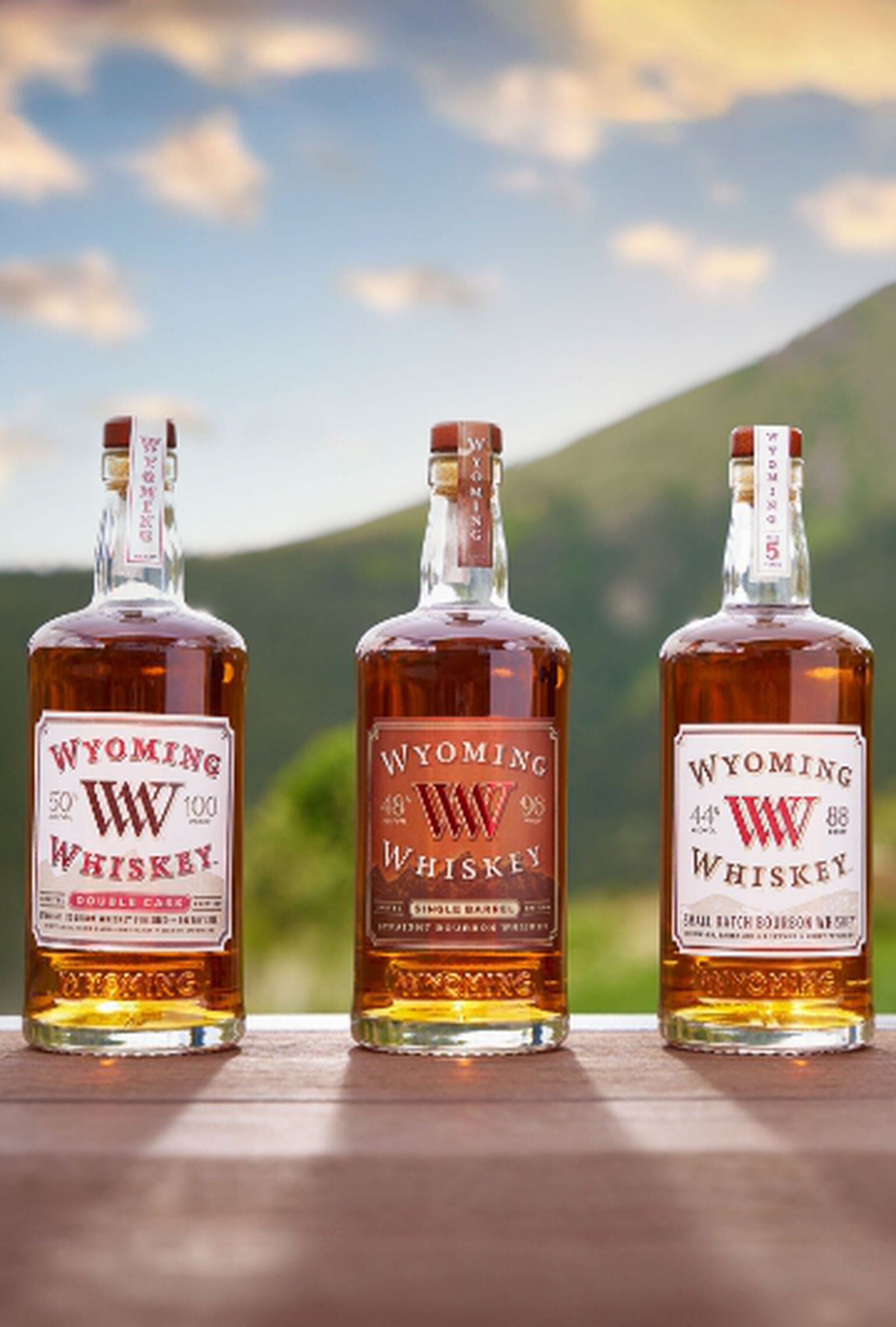 3 Bottles of Wyoming Whiskey with a mountain in the background